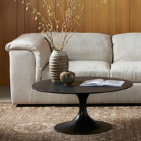 Sabine Round Coffee Table in Raw Black, featuring a sleek design and modern pedestal base.