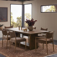Front view of the Thalia Dining Table showcasing its rich wood finish and spacious design, complemented by elegant seating.