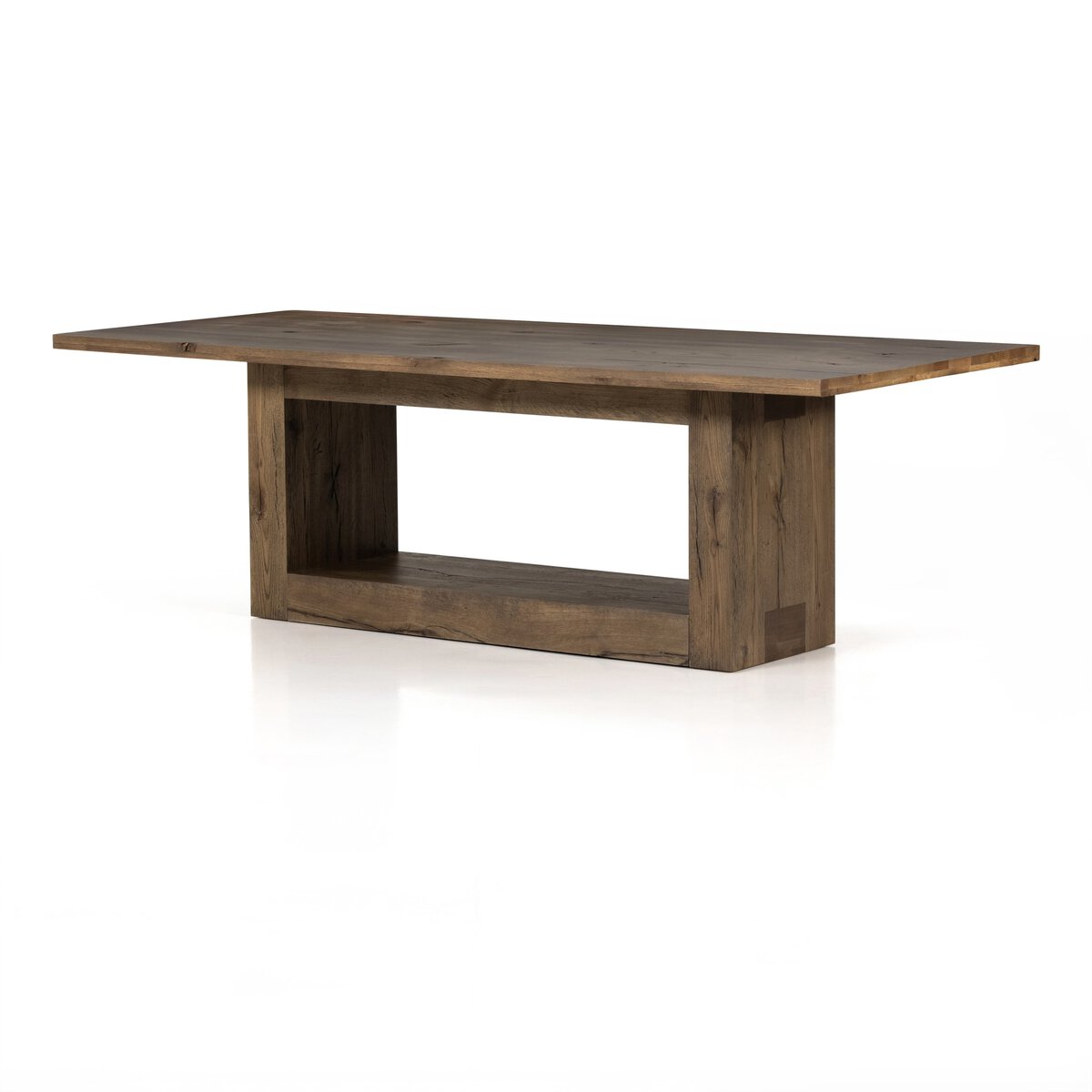 Three-quarter view of the Thalia Dining Table, showcasing its rustic wood finish and open base design.