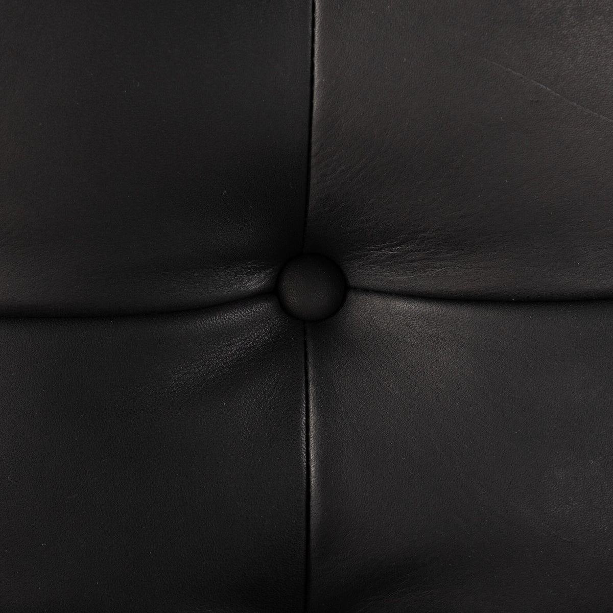Close-up of the Langston Chair's Heirloom Black leather upholstery and tufted detail.