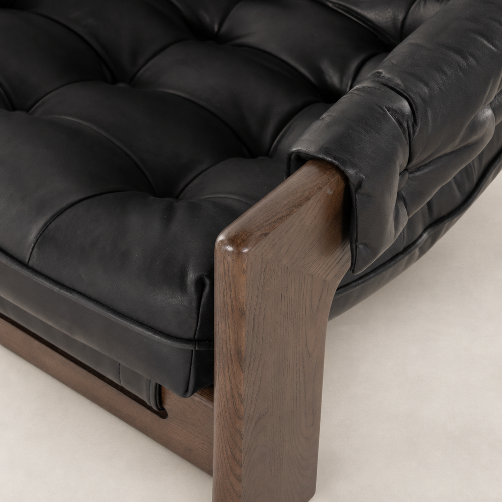 Langston Chair in heirloom black, featuring tufted leather upholstery and a wooden armrest.