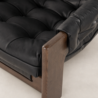 Langston Chair in heirloom black, featuring tufted leather upholstery and a wooden armrest.