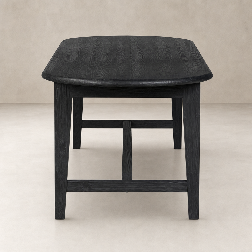 Savona Dining Table in black pine, featuring a smooth curved edge and sturdy legs.