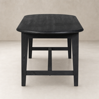 Savona Dining Table in black pine, featuring a smooth curved edge and sturdy legs.