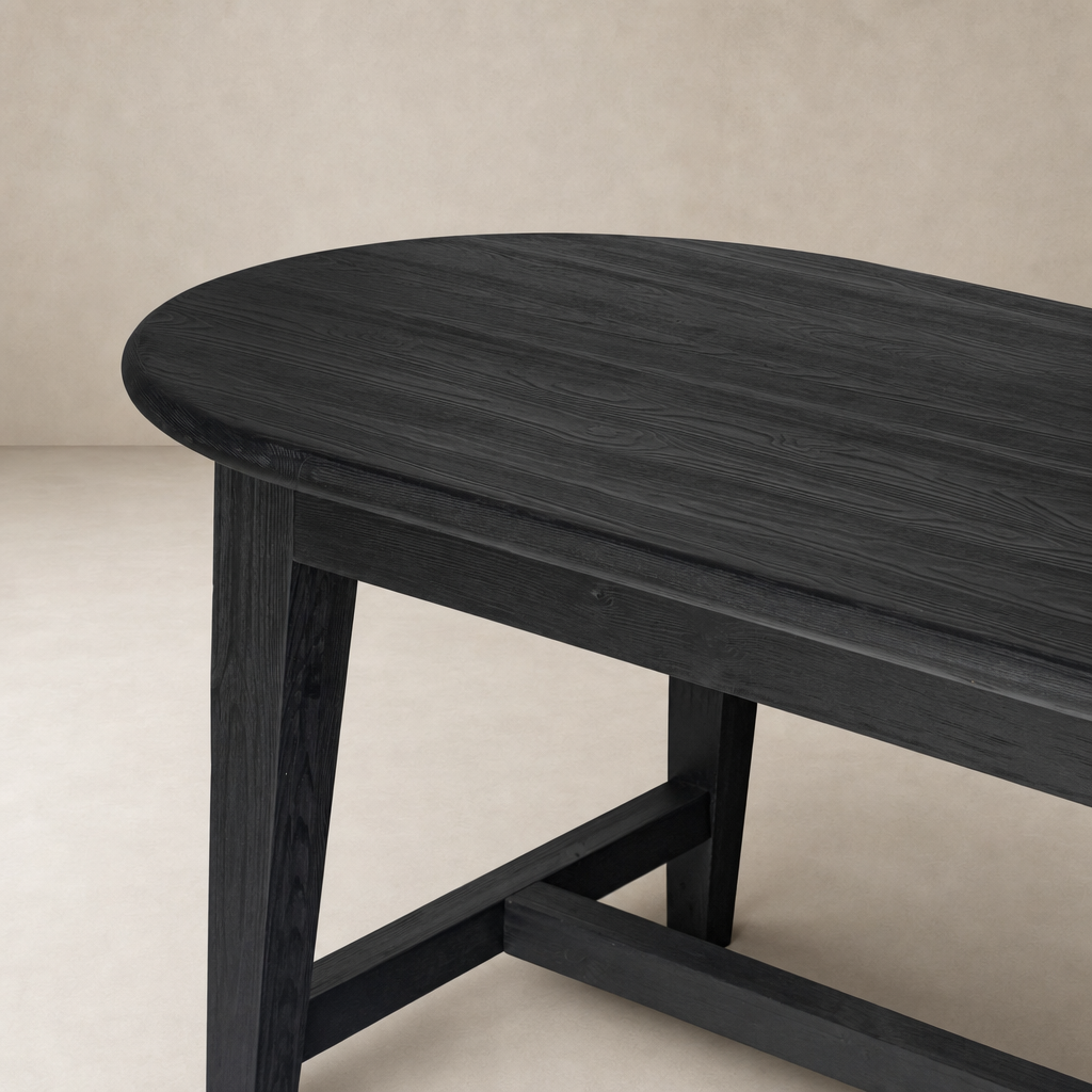Savona Dining Table in black pine with a smooth, oval-shaped top and sturdy legs.