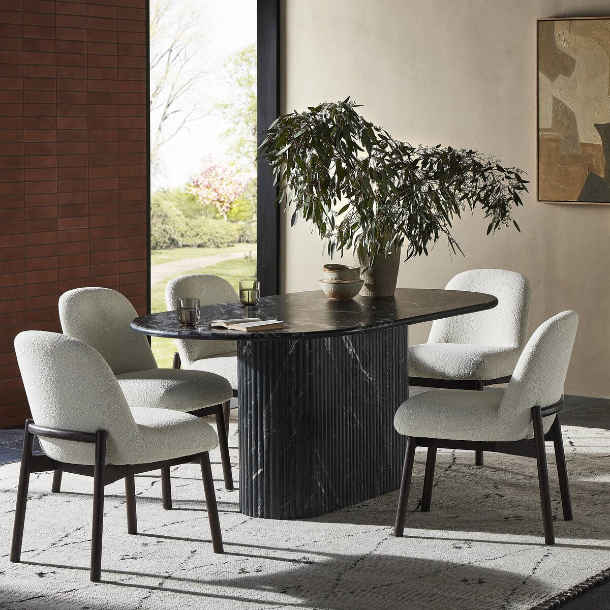 Elegant Elysia Dining Table in a modern setting, featuring a dark marble top and ribbed base.