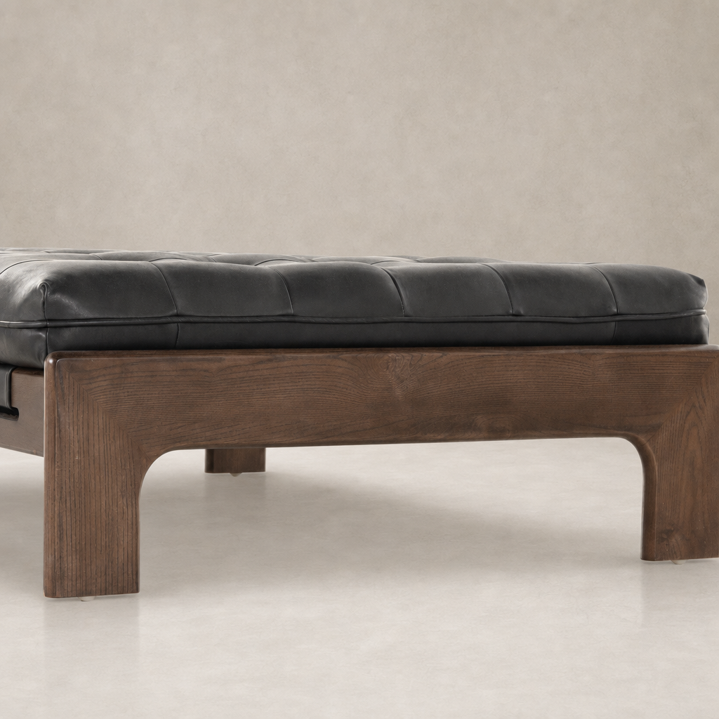 Hudson Cocktail Ottoman in Heirloom Black with a sleek, tufted design and wood legs.