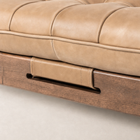 Close-up of Hudson Cocktail Ottoman in Palermo Drift with tufted leather seat and wood base.