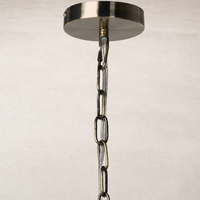 Ceramic pendant in aged black terracotta with a decorative chain detail.