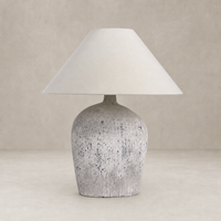 Antique white ceramic table lamp with a conical shade and textured base.