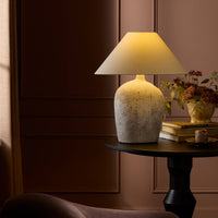 Antique white ceramic table lamp with a stylish shade, illuminating a cozy setting.