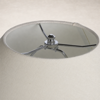Close-up of the chrome fitting inside an antique white ceramic table lamp shade.