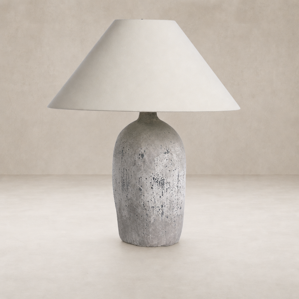 Antique white ceramic table lamp with a textured base and fabric shade.