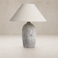 Antique white ceramic table lamp with a textured base and fabric shade.