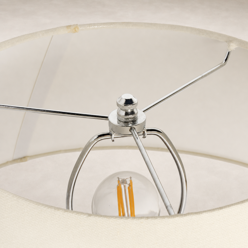 Close-up of a table lamp's chrome socket and decorative light bulb.