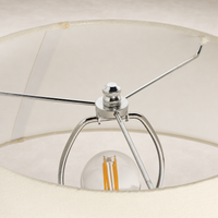 Close-up of a table lamp's chrome socket and decorative light bulb.