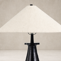 Matte black cast aluminum tapered shade table lamp with a light fabric shade.