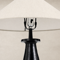 Matte black cast aluminum tapered shade table lamp with a fabric lampshade.