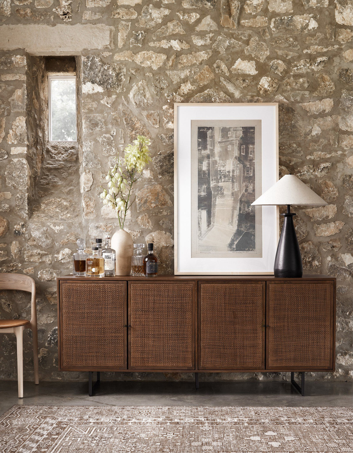 Matte black cast aluminum tapered shade table lamp on wooden sideboard.