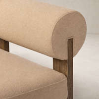 Isla Chair in Piermont Sand featuring a rounded back and wooden legs.