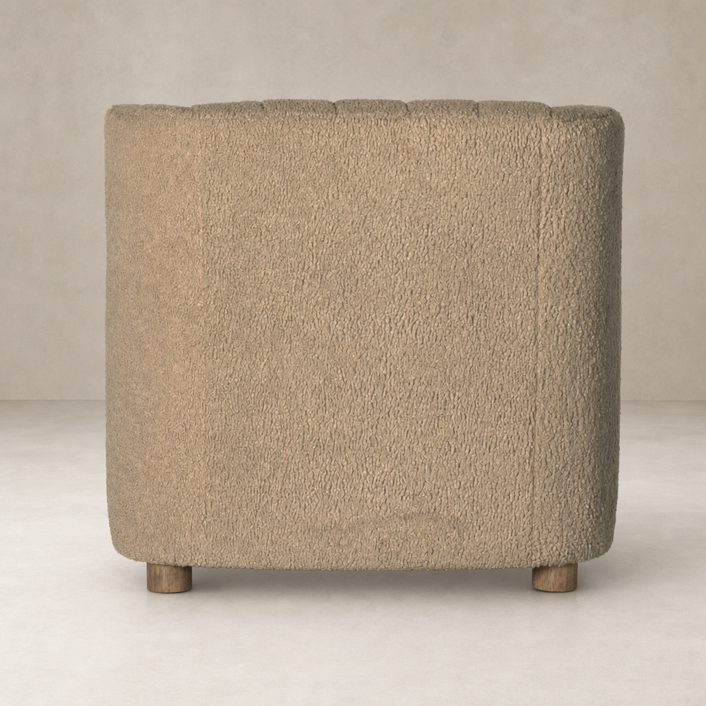 Baldwin Chair in sheepskin camel with a textured, rounded shape and wooden legs.