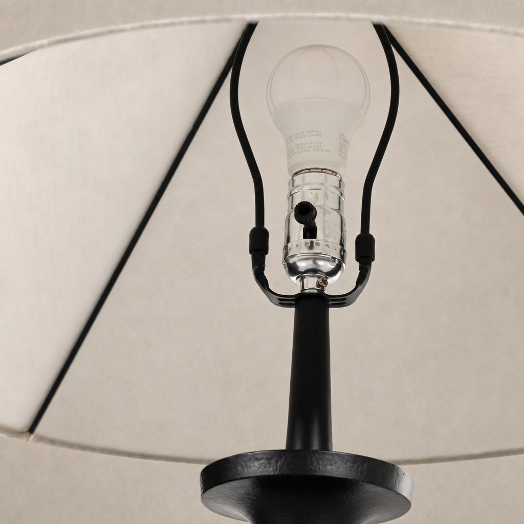 Matte black cast aluminum tapered shade floor lamp showcasing light bulb and socket details.