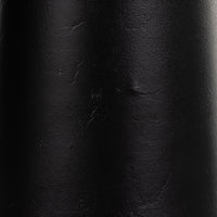 Textured matte black cast aluminum of a tapered shade floor lamp.