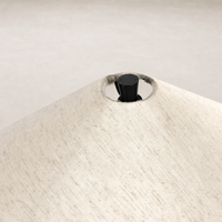 Close-up of tapered shade floor lamp with matte black cast aluminum fittings.