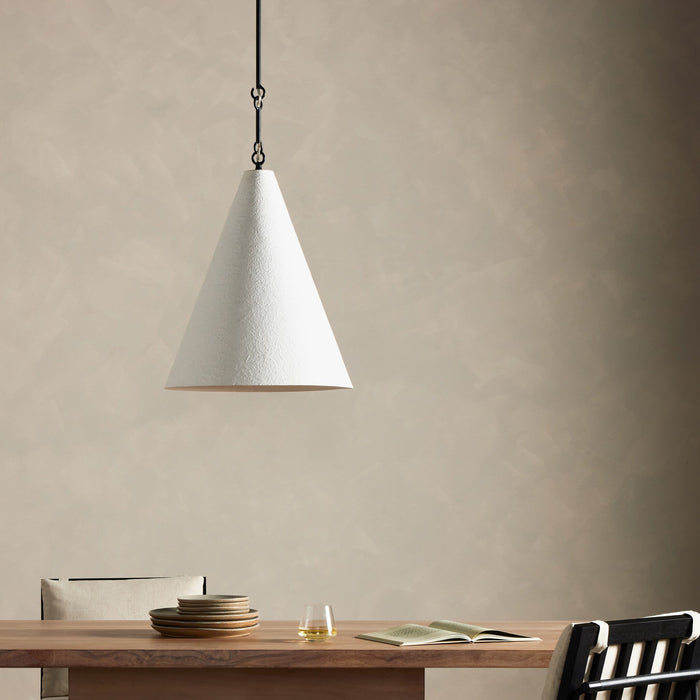 Matte white plaster pendant light hanging over a wooden dining table.