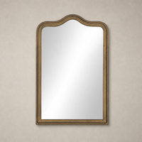 Elegant Etta Mirror in Raw Antique Brass Iron with a wavy top design.