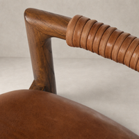 Close-up of Nadia Bar + Counter Stool's Haven Tobacco leather seat and wooden armrest.