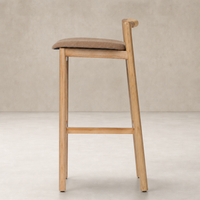 Nadia Bar + Counter Stool in Antwerp Cafe features a sleek wood frame and plush seat.