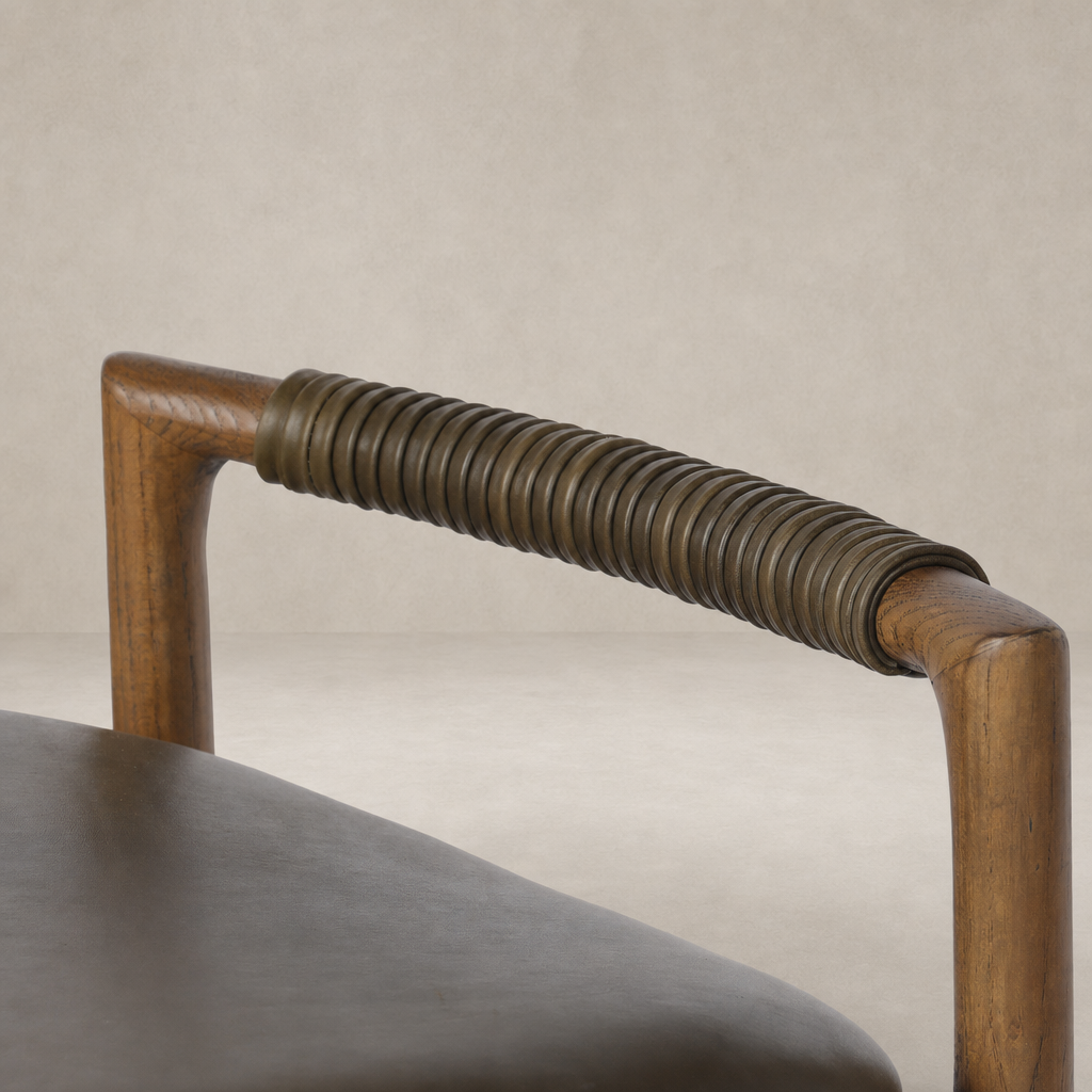 Detail of Nadia Bar + Counter Stool in Dulane Moss, showcasing its unique coiled armrest design.