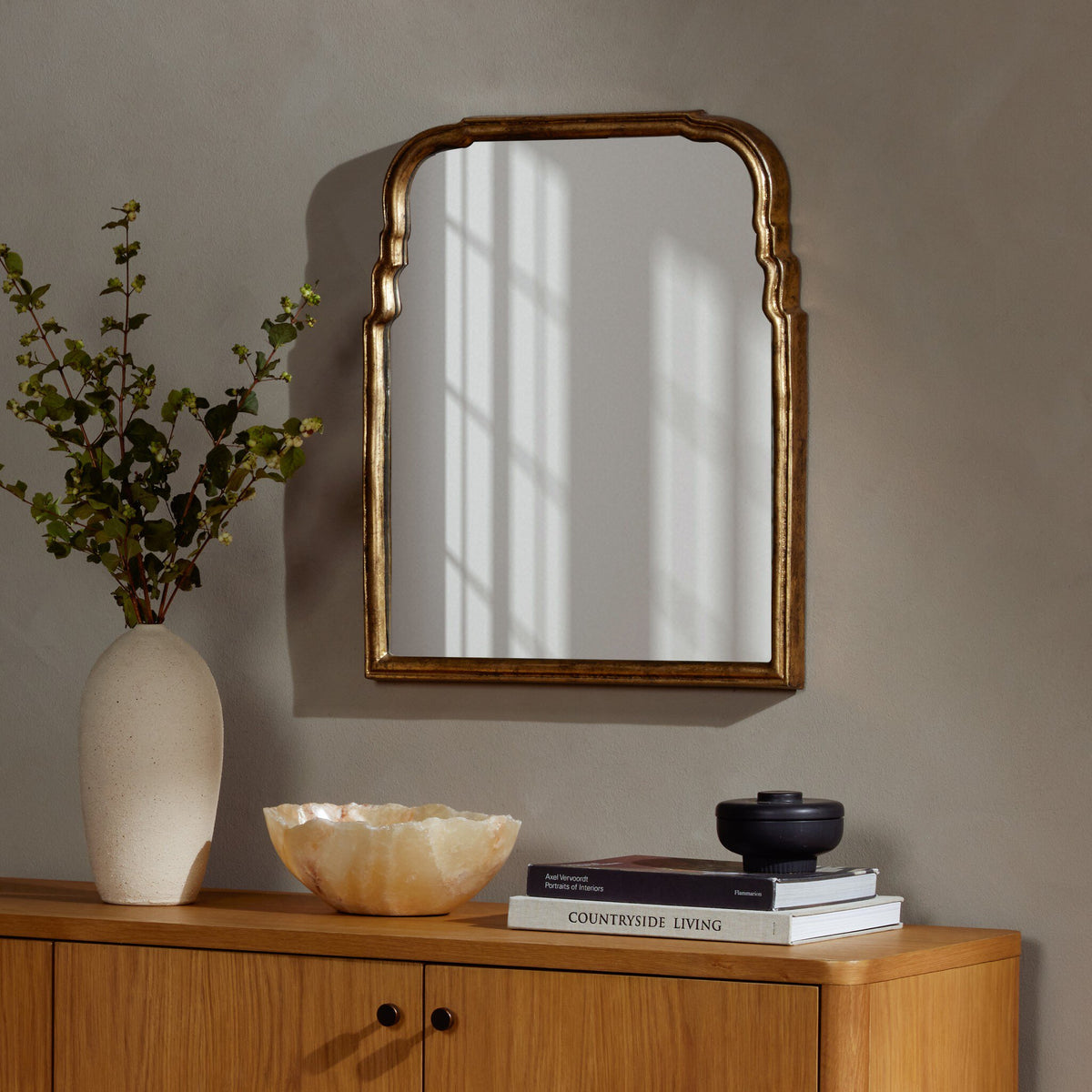 Antiqued Gold Leaf Rhone Mirror with an elegant arched design in a stylish decor setting.