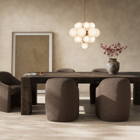 Brisa Dining Table in ebony rustic wormwood oak with a natural finish, styled in a cozy dining room.
