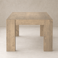 Brisa Dining Table in whitewash rustic wormwood oak with sturdy, square legs and textured surface.