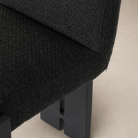 Romy Dining Chair in Gibson Black featuring textured upholstery and sturdy wooden legs.