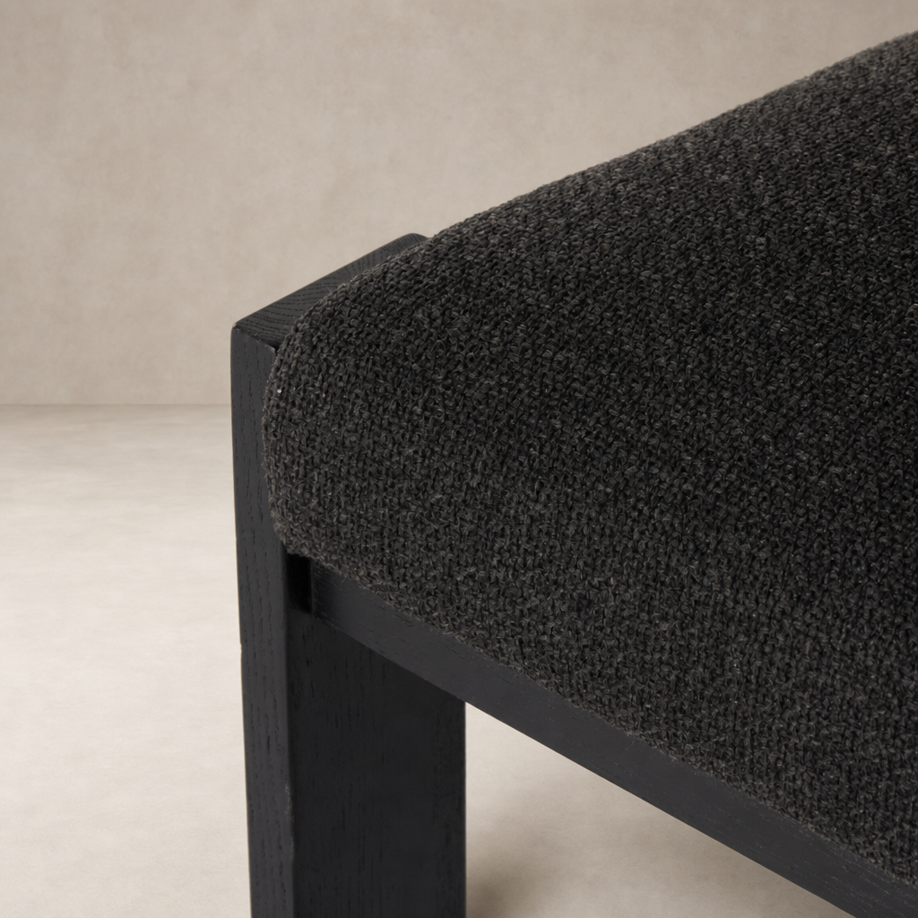 Close-up of the Romy Dining Chair in Gibson Black, showing textured fabric and sturdy frame.