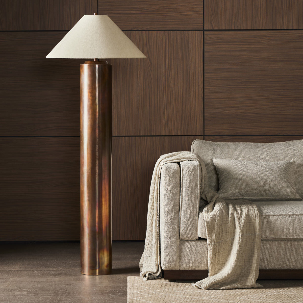 Iridescent acid wash floor lamp with a conical shade beside a cozy couch.