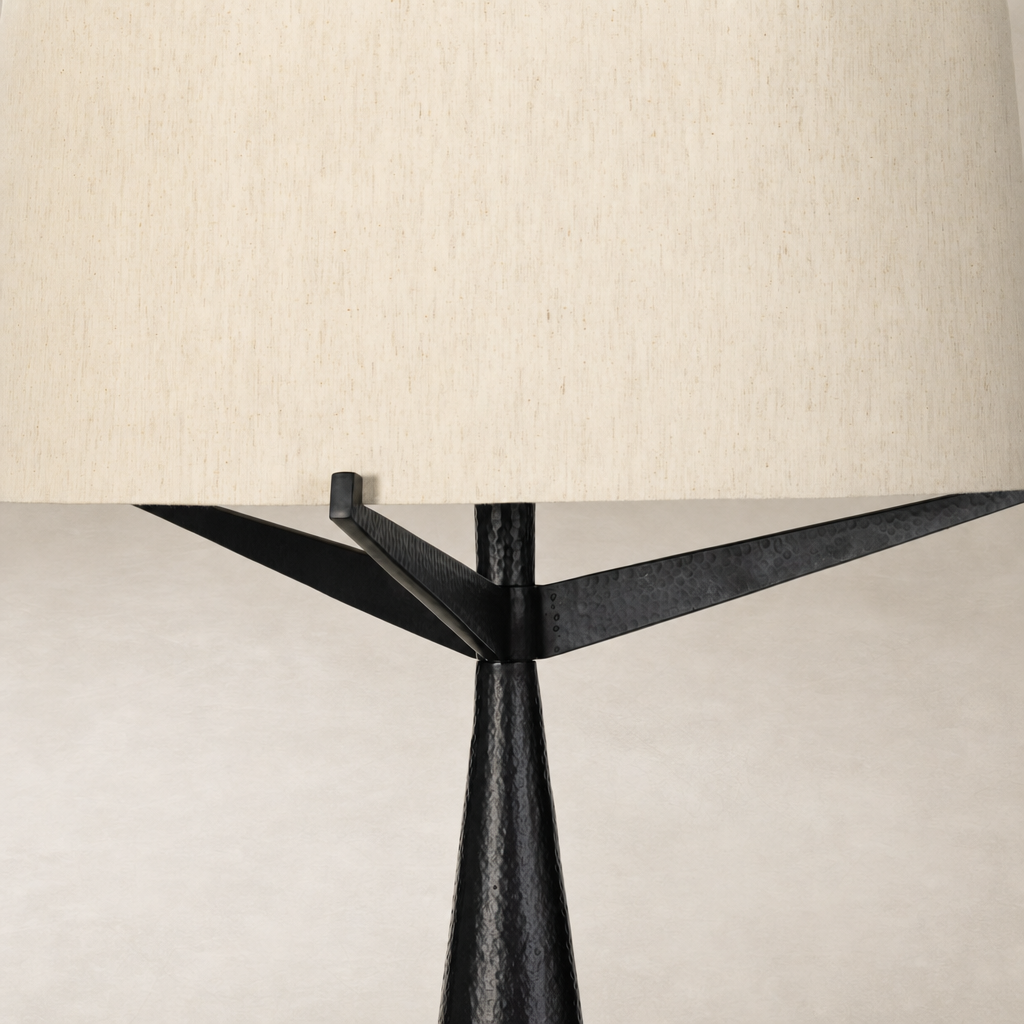 Hammered black aluminum floor lamp with a textured base and cream fabric shade.
