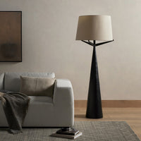 Hammered black aluminum floor lamp with a soft fabric shade in a cozy living room scene.