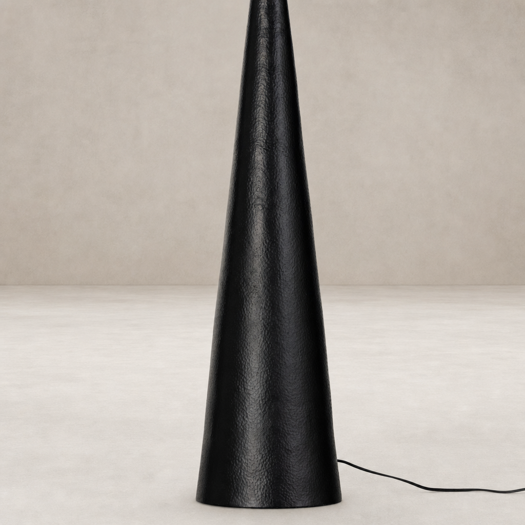 Hammered black aluminum floor lamp with a sleek, conical design.