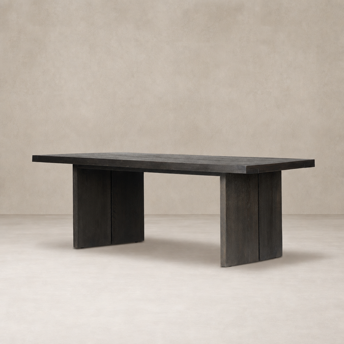 Sevilla Dining Table in worn black oak with a sleek, modern design and sturdy legs.