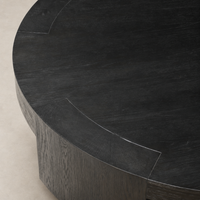 Hastings Coffee Table in Charcoal Oak featuring a sleek round design and textured finish.