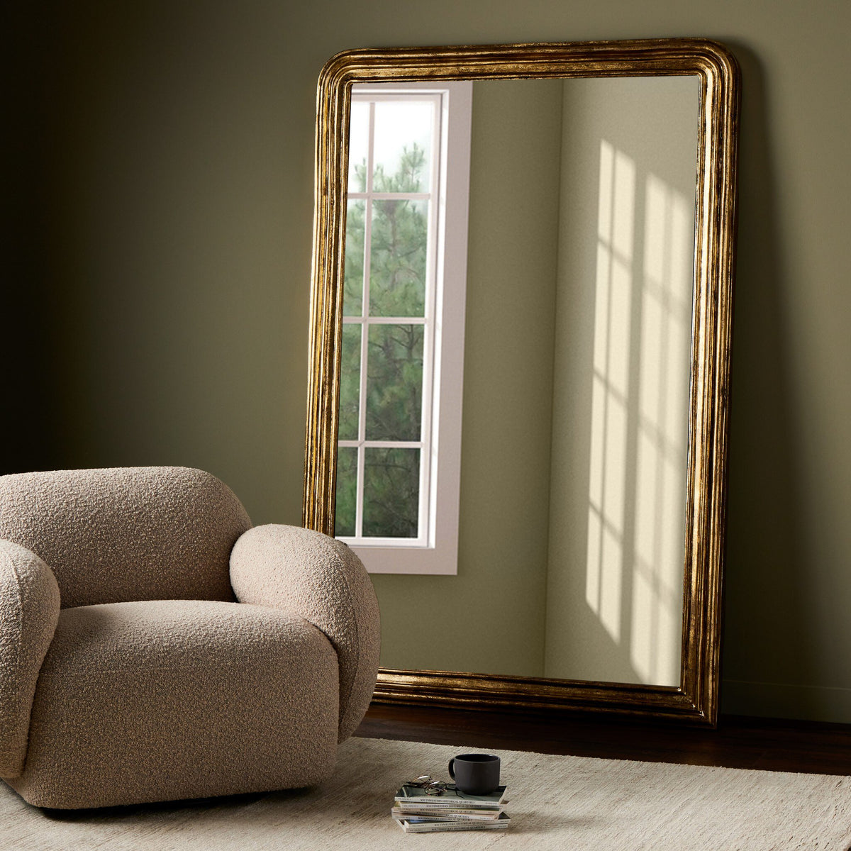 Vesper Louis Floor Mirror with antiqued gold leaf frame leaning against a wall.