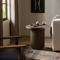 Ashford End Table in a modern living room with a round top and ribbed base.