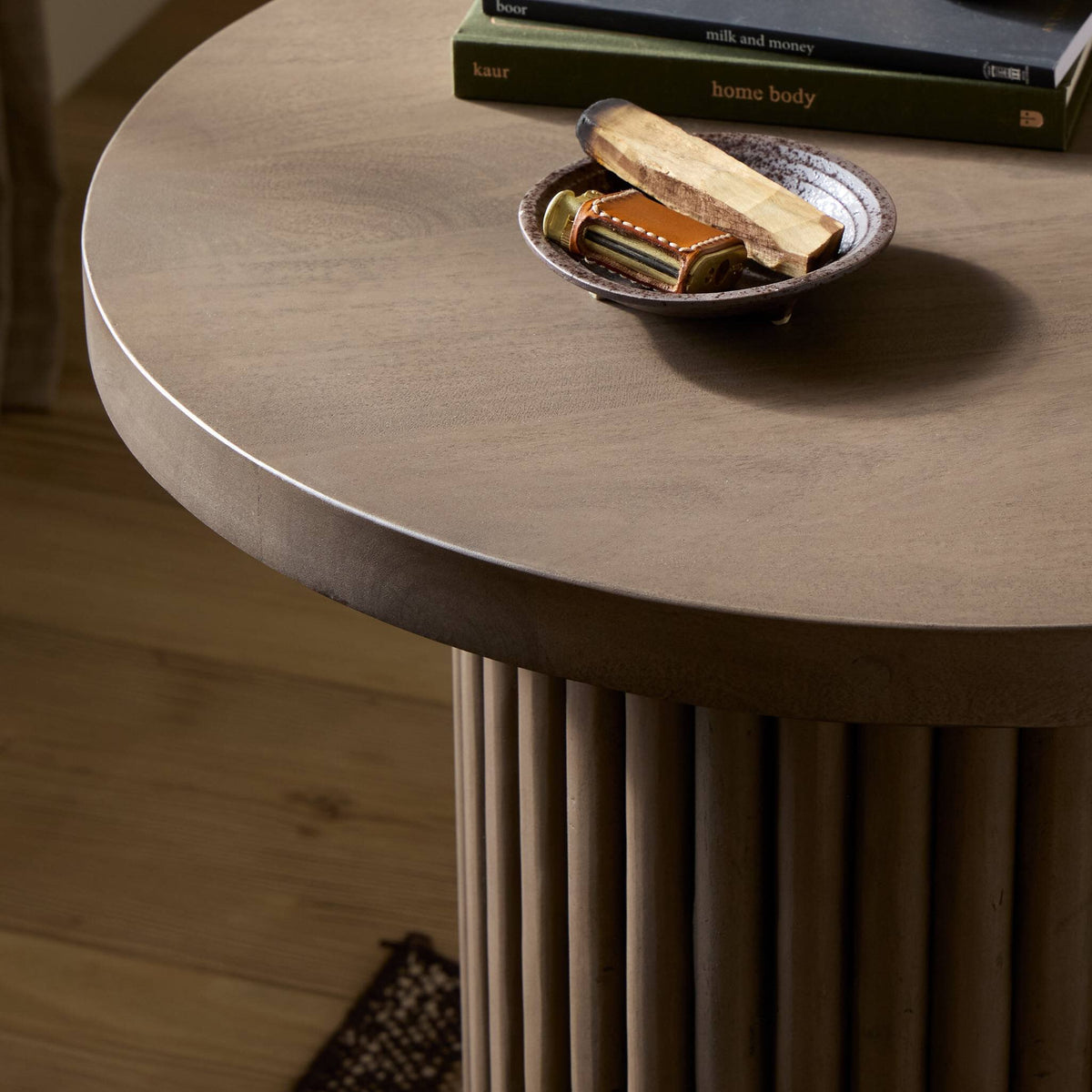 Ashford End Table with a round top and stylish ribbed base, showcasing a neutral finish.