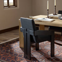 Gibson Black dining armchair with unique detailing and upholstered backrest in a stylish room.