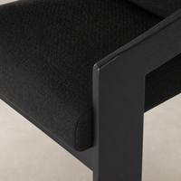 Elegant dining armchair in Gibson Black with textured upholstery and sleek wooden frame.