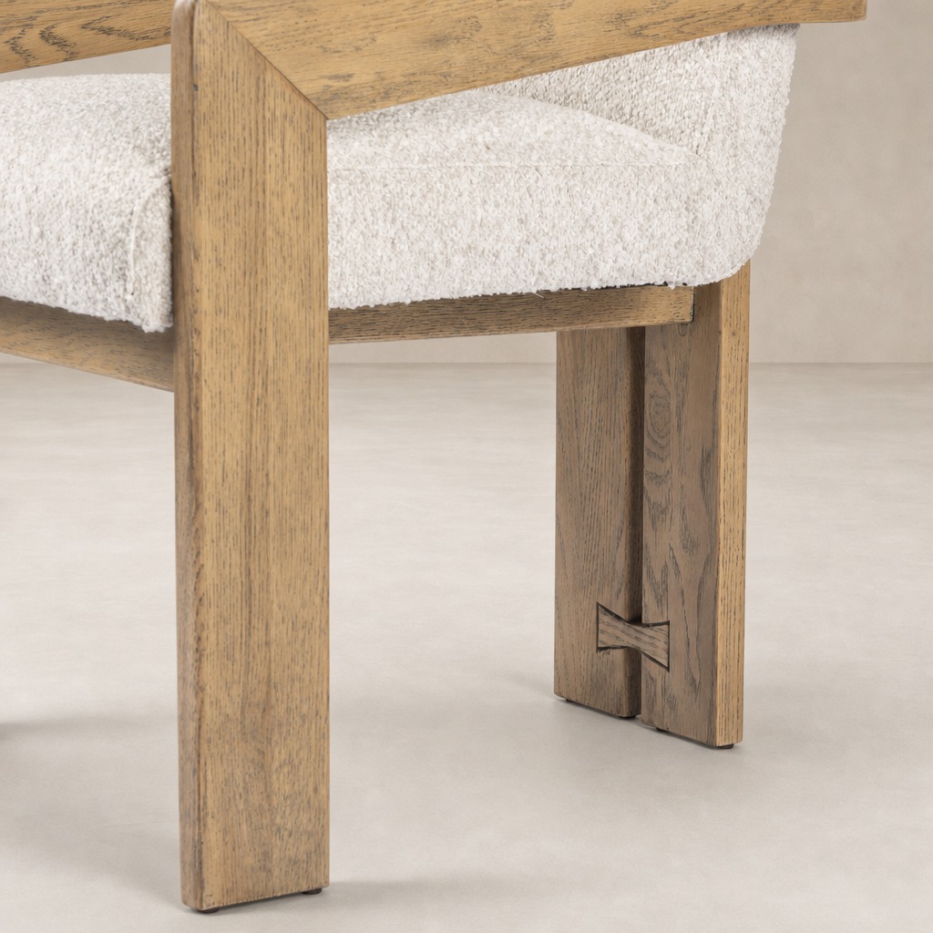 Detail of a Somerton Ash dining armchair showcasing its wooden frame and plush seat.